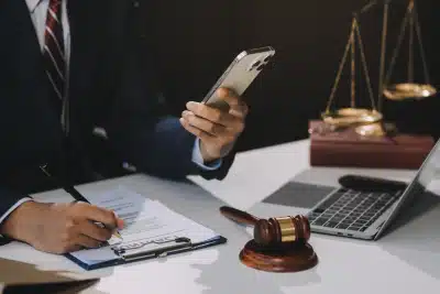 A tax lawyer looking at his phone and updating a client regarding their case.