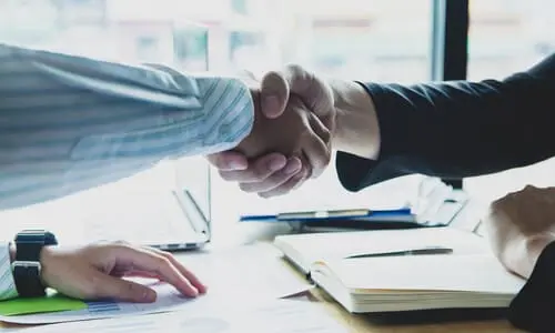 A handshake between a taxpayer and an IRS agent after coming to an agreement to abate taxes.