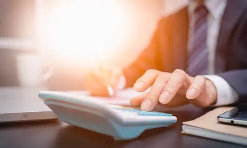 A tax professional on a calculator working to get wage garnishments removed from a client.