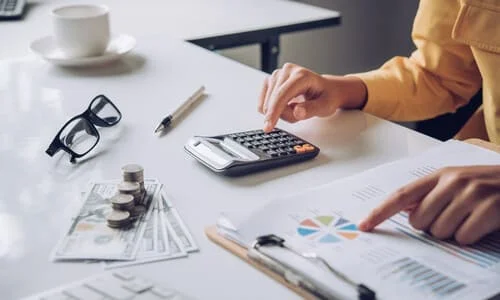 A businesswoman looking at her earnings and calculating her taxes.