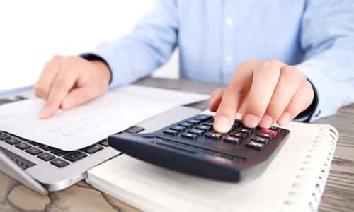 A tax expert with a calculator working on a federal tax lien removal for a client.