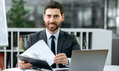 A freelancer filing 1099 tax forms and other documents at a desk.