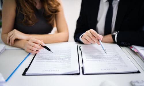 A first-person shot of a tax professional assisting a couple with securing an offer in compromise from the IRS.