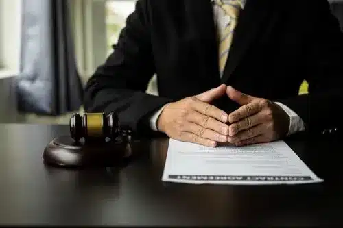 Close up of tax lawyer at his desk with hands crossed.