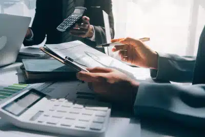 A team of tax professionals with calculators working on a bank levy release.