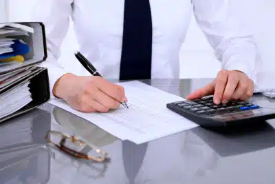 A tax expert working with logbooks and a calculator to secure a client's IRS penalty relief.