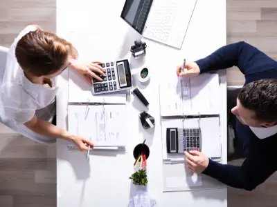 An overhead shot of a professional assisting a client with their taxes.