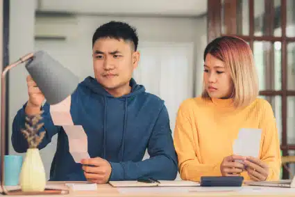 A couple having trouble computing their business taxes and holding up receipts.