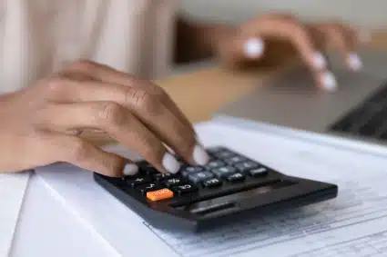 A person calculating her budget after receiving a wage garnishment from poorly handled taxes.