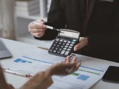 Castle Rock tax lawyer reviewing a client’s tax documents and pointing to calculations on a calculator.