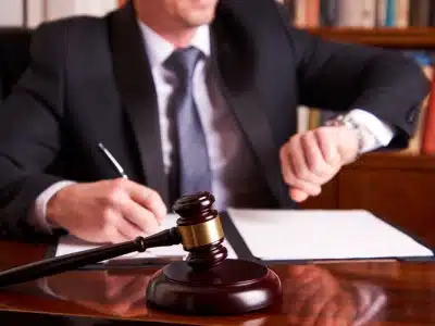 A Littleton Tax Lawyer working in his office while looking at the time on a watch on his left hand
