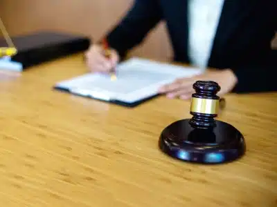 A blurred shot of a Parker Tax Lawyer writing on their desk while the image is focused on the hammer and gavel on the table
