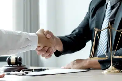 An El Segundo tax lawyer sits in front of a satisfied client while they shake each other's hands