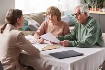 A senior couple sits at a table discussing their tax issues with a Bozeman tax lawyer.