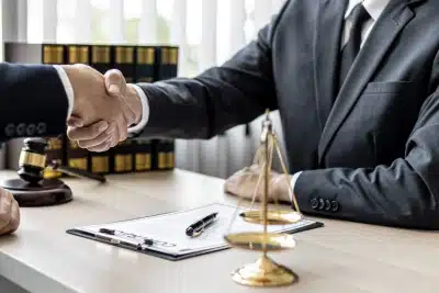 A tax lawyer serving Ladera Heights shakes the hand of a client after signing a contract placed on the table between them
