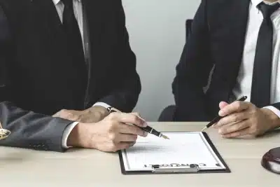 A pair of Lawndale tax lawyers sit together while they discuss the contents of a document placed on a table in front of them