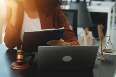 A Bozeman tax lawyer holding up and reading legal documents while resting one arm on an office desk