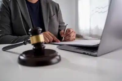 A Bozman tax debt relief lawyer writes on a document while looking at an open laptop